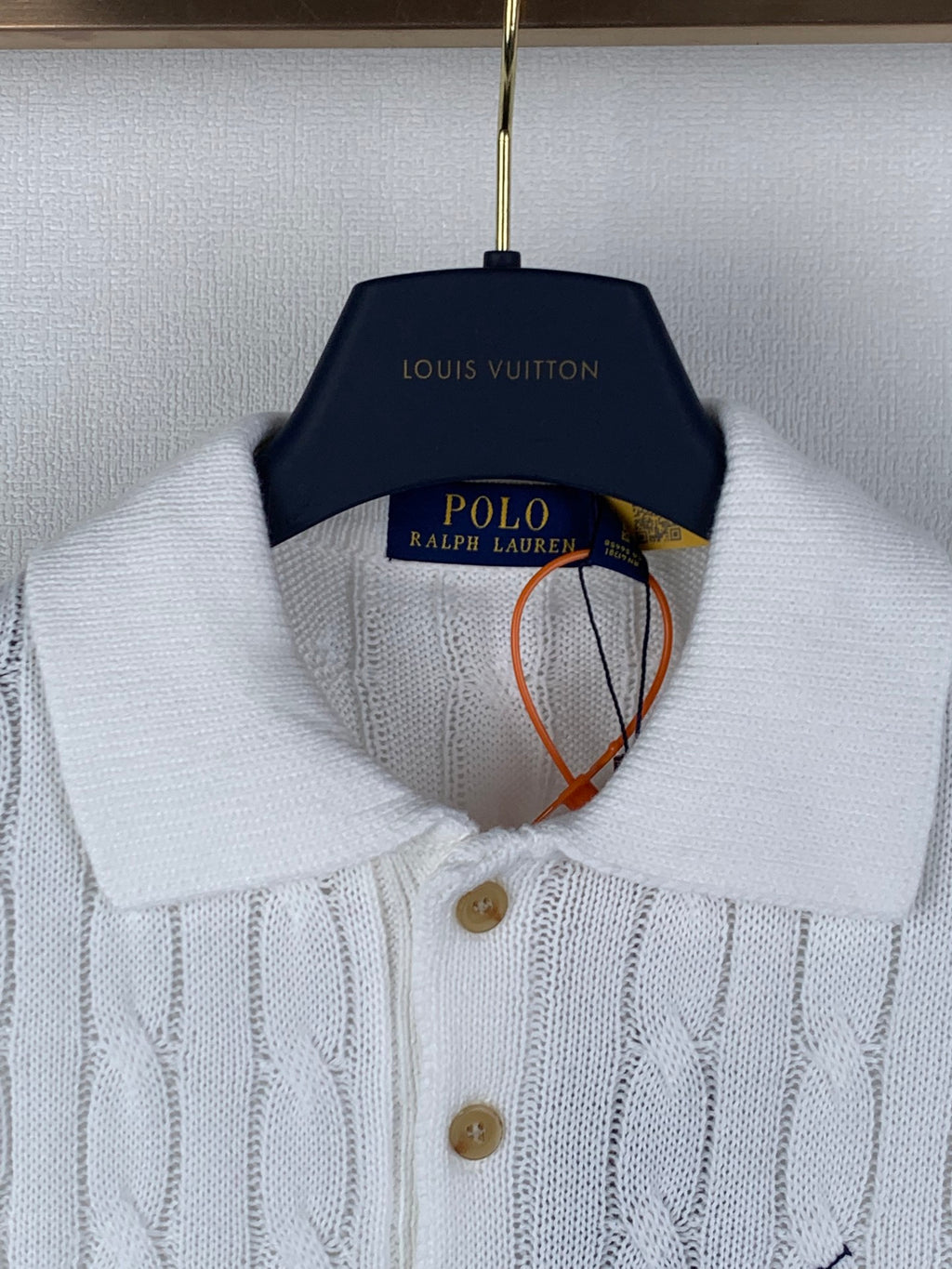 White cable-knit polo shirt collar with button placket and small embroidered logo