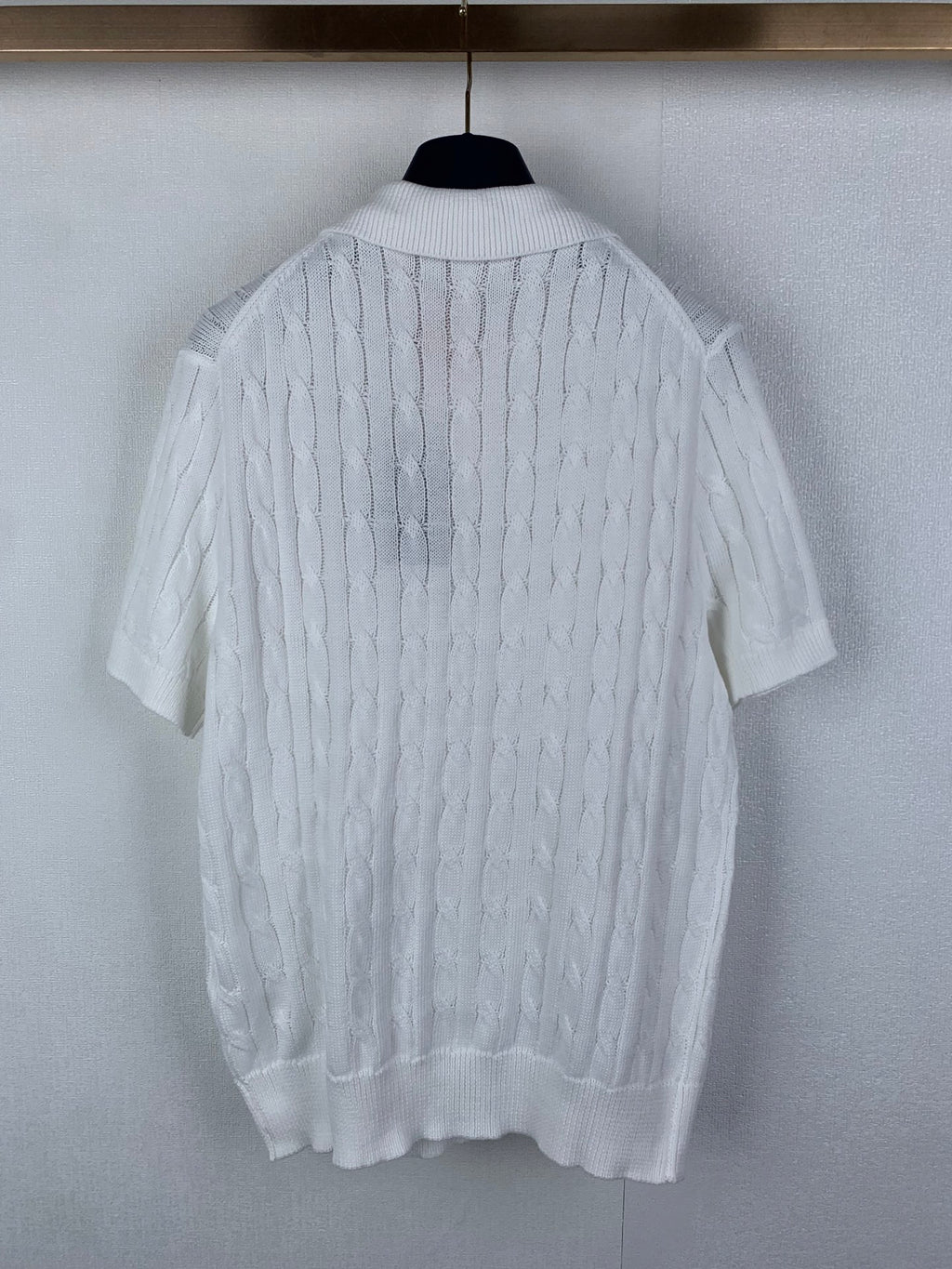 White cable-knit polo shirt with short sleeves and ribbed hem