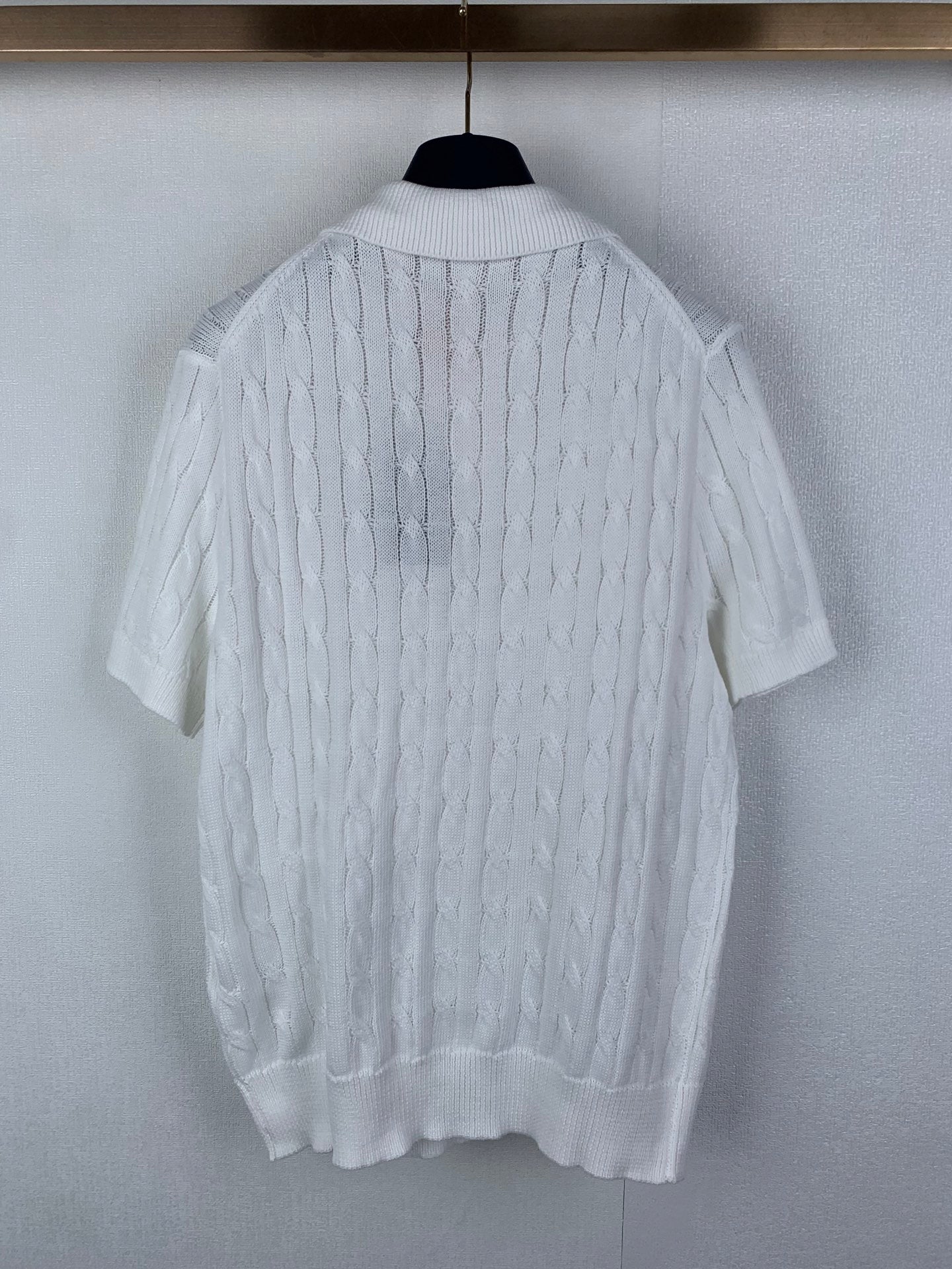 White cable-knit polo shirt with short sleeves and ribbed hem