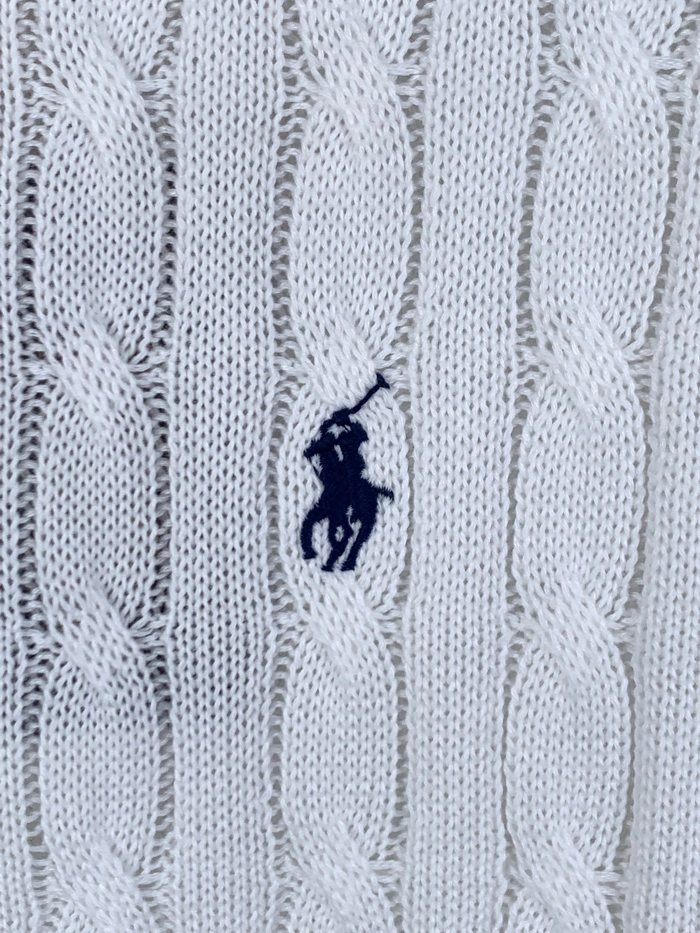 White cable-knit polo shirt fabric with small embroidered pony logo