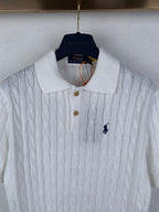 White cable-knit polo shirt with collared neckline, button placket, and small logo