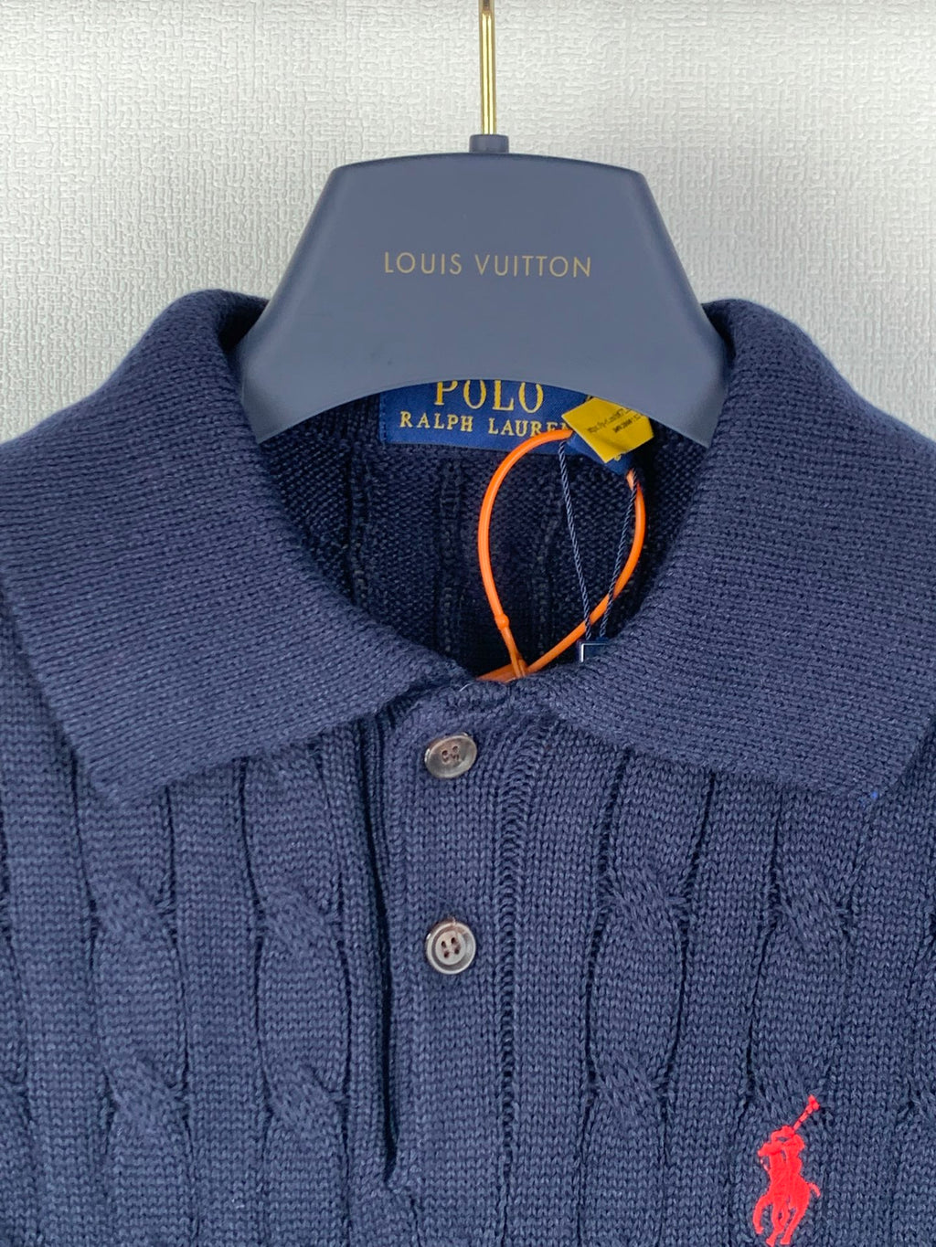 Dark navy knit polo with button placket, ribbed collar, red polo logo