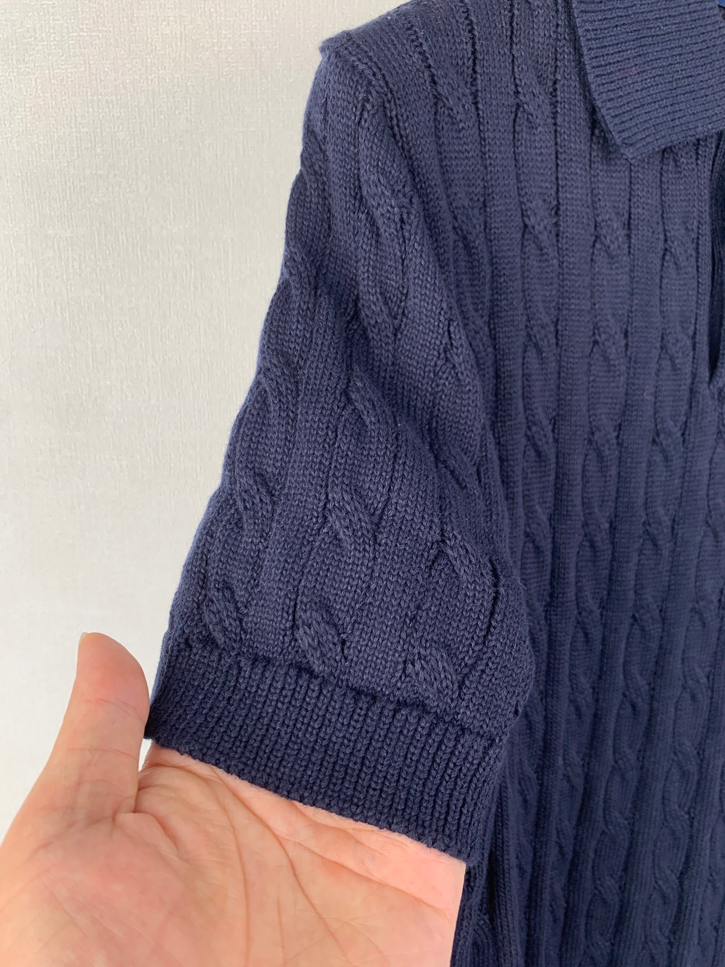 Dark navy cable-knit polo shoulder and sleeve with ribbed knit texture
