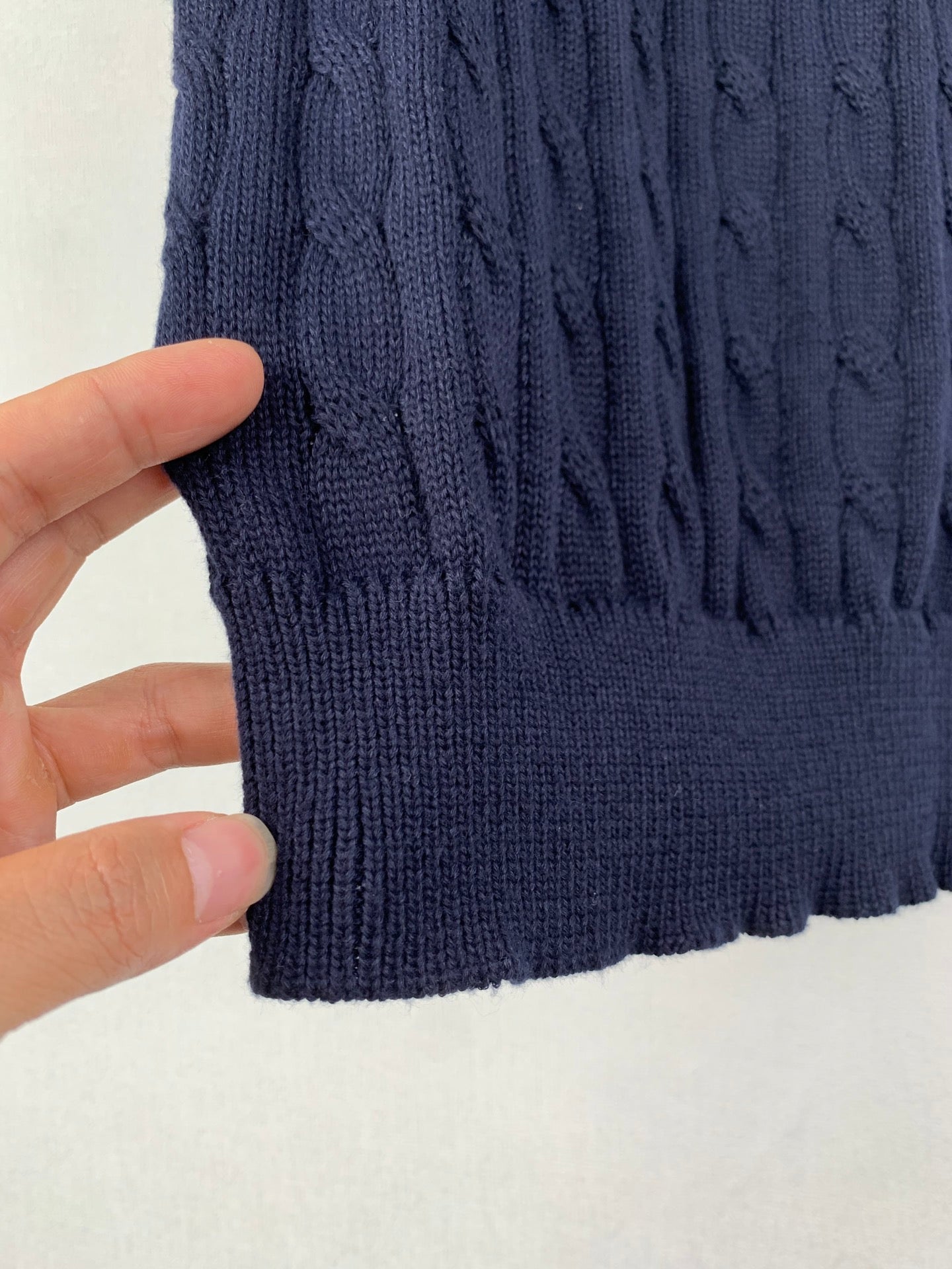 Dark navy cable-knit polo hem with ribbed trim