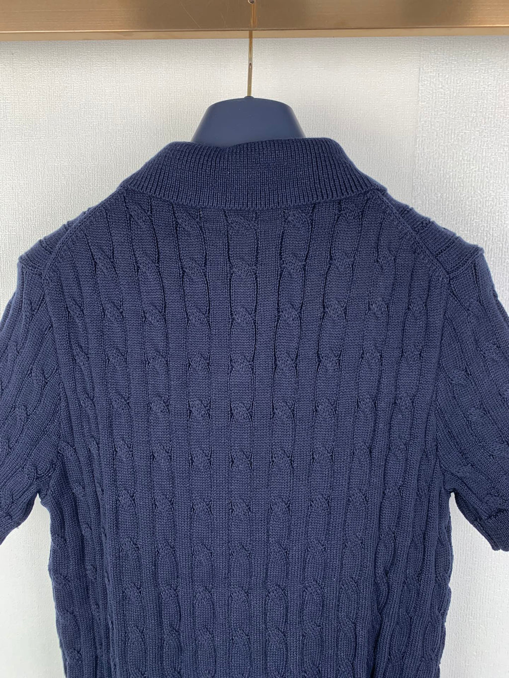 Dark navy cable-knit polo shirt back with ribbed collar and textured knit