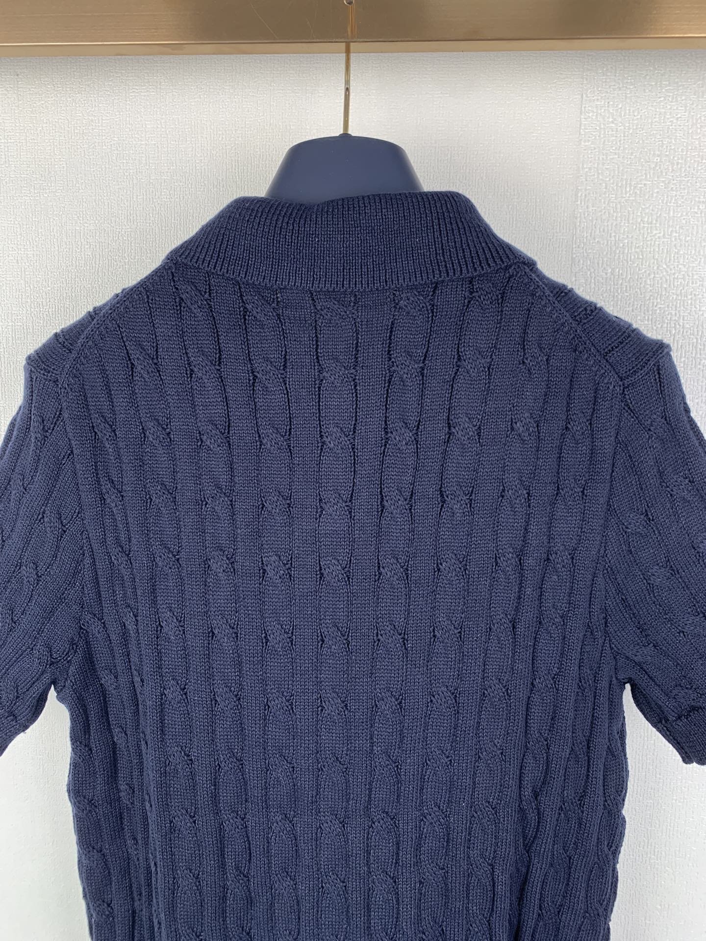 Dark navy cable-knit polo shirt back with ribbed collar and textured knit