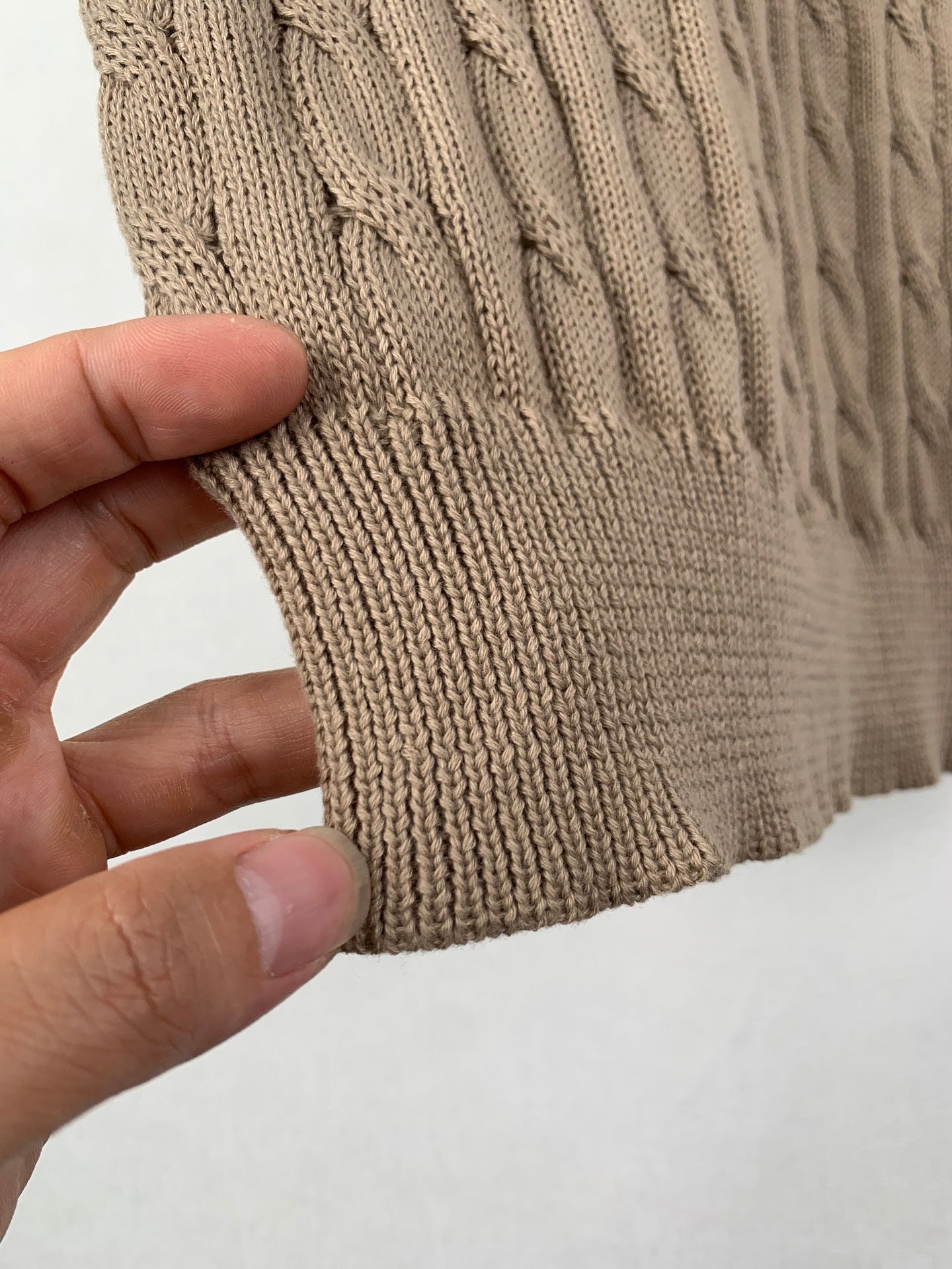 Ralph Lauren knit polo hem ribbing close-up with hand holding the fabric