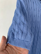 Light blue knit sweater sleeve cuff and cable knit shoulder detail