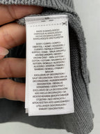 Gray knit polo shirt care label: made in Bangladesh, 100% cotton
