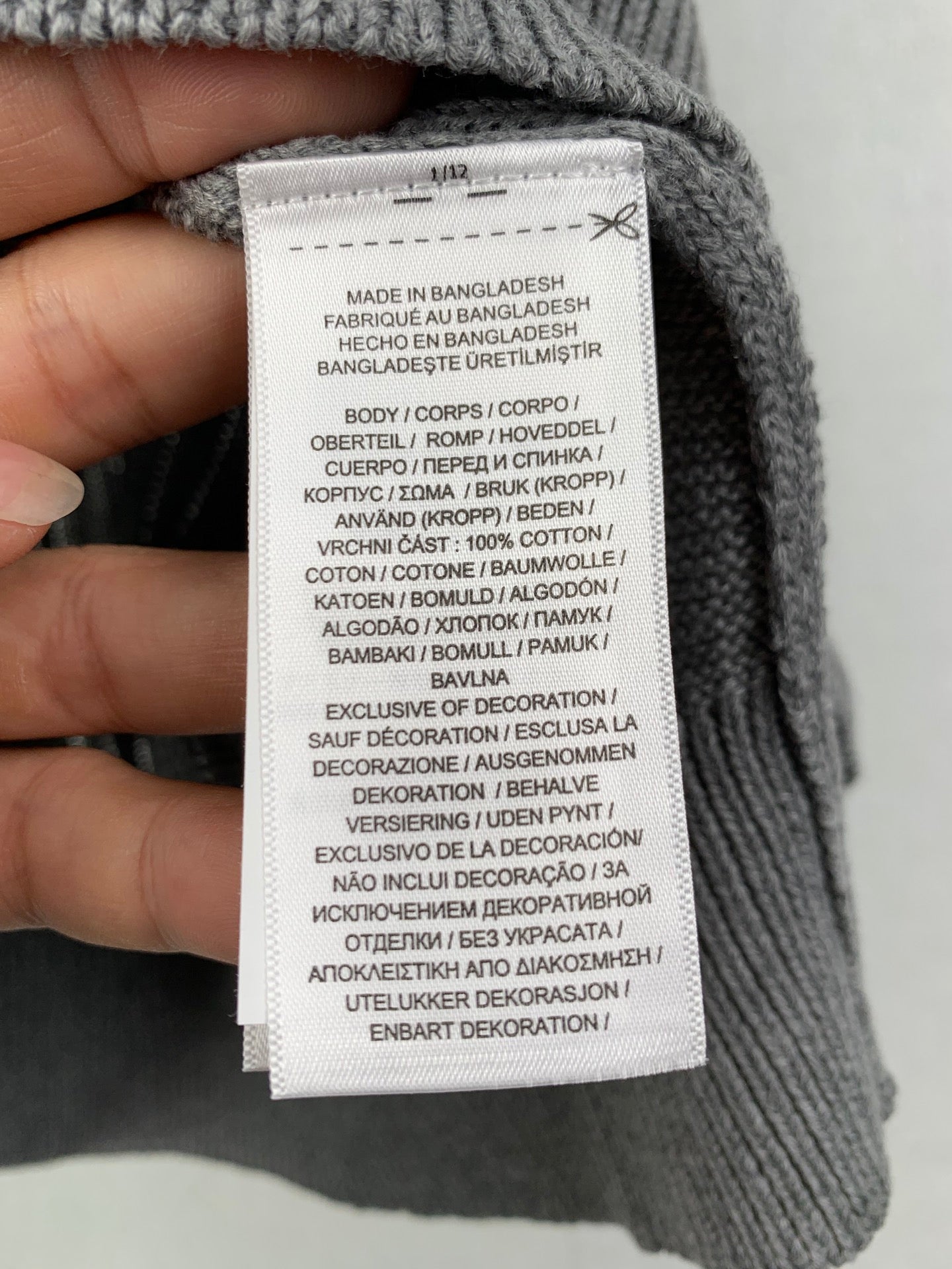 Gray knit polo shirt care label: made in Bangladesh, 100% cotton