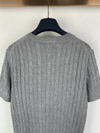 Gray knit polo shirt back close-up showing cable knit texture and ribbed neckline