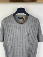 Gray knit polo shirt front view, crew neck ribbing, short sleeves, small navy logo