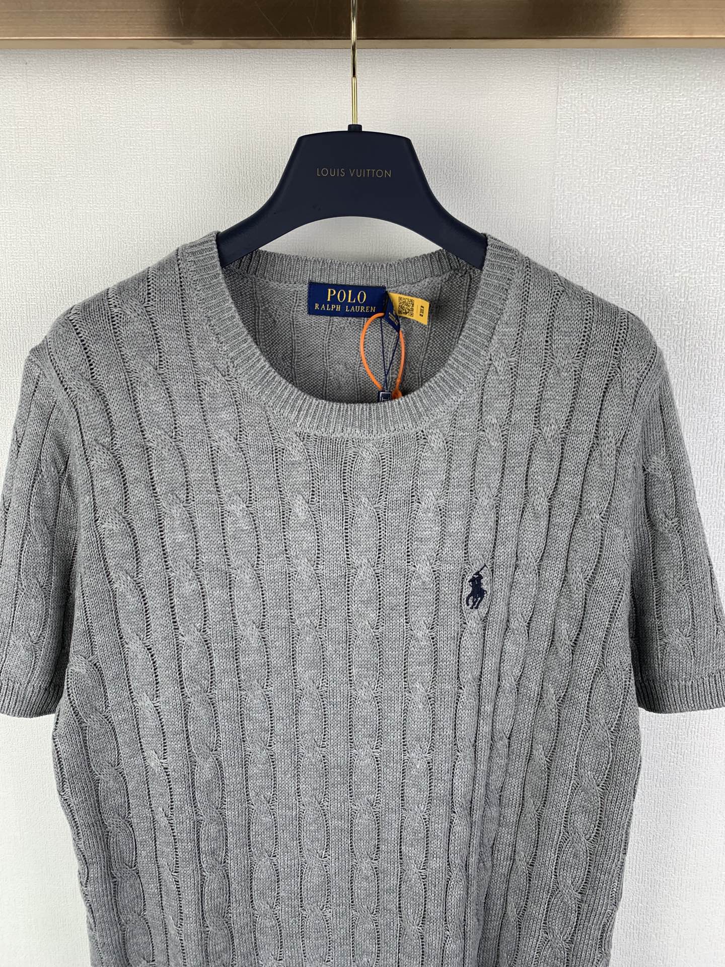 Gray knit polo shirt front view, crew neck ribbing, short sleeves, small navy logo