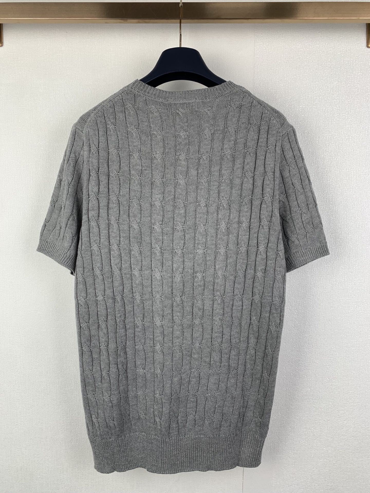 Gray knit polo shirt back view with cable texture and ribbed crew neckline