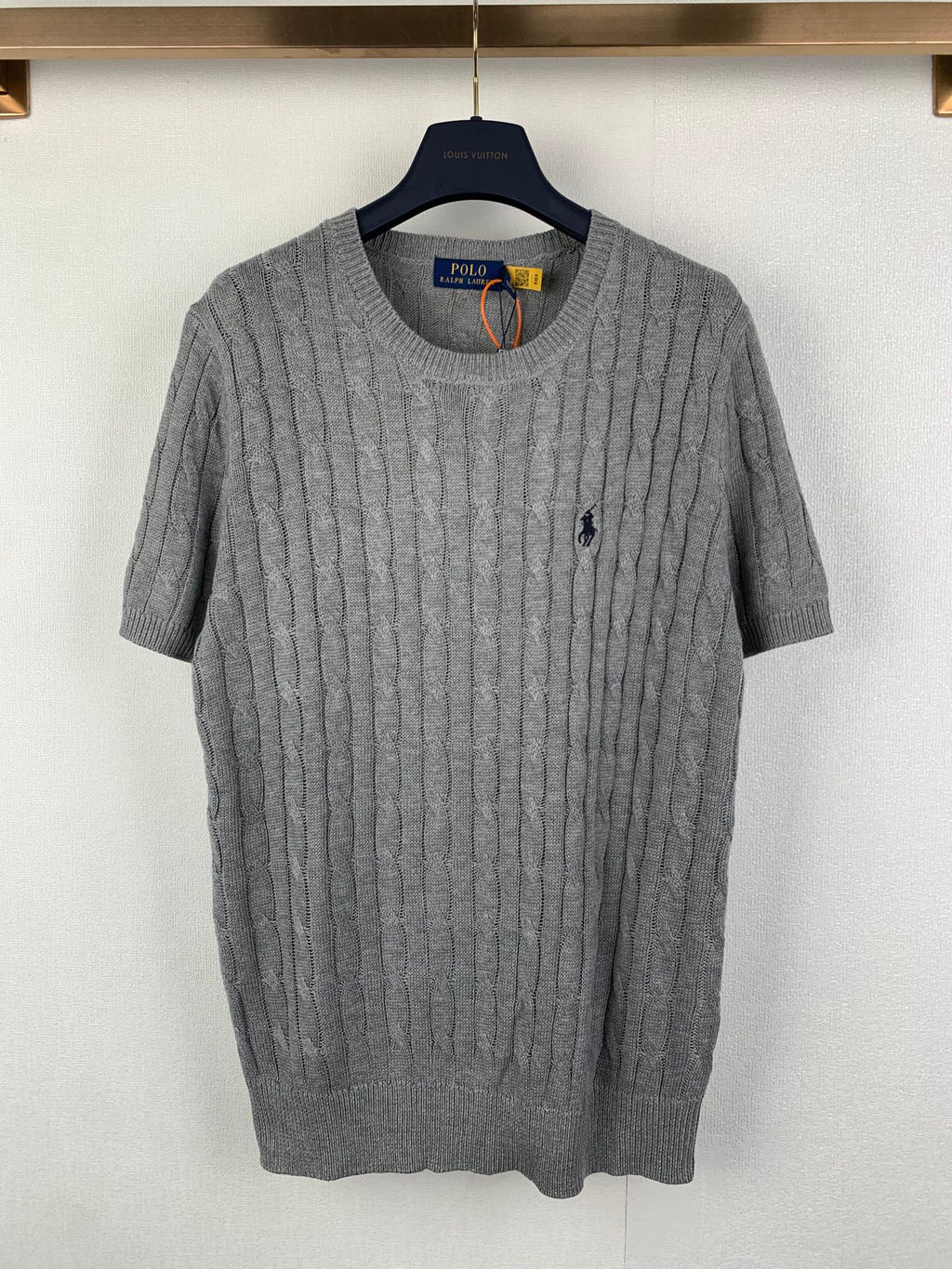 Gray knit polo shirt with cable texture, crew neck and short sleeves, small navy logo