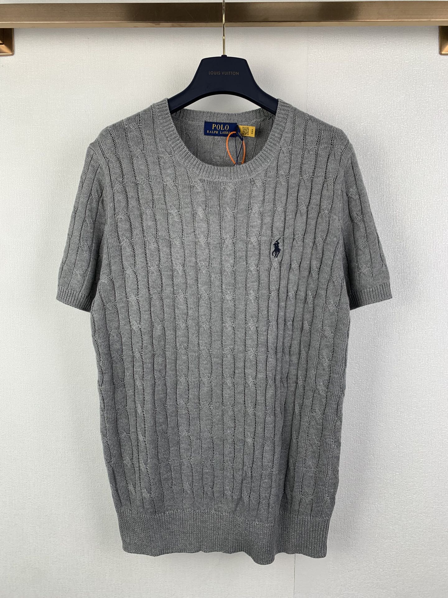 Gray knit polo shirt with cable texture, crew neck and short sleeves, small navy logo