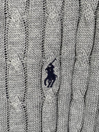 Gray cable-knit polo shirt with small navy embroidered logo on the chest