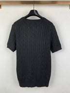 Cable-knit sweater back view in dark knit with short sleeves and ribbed hem