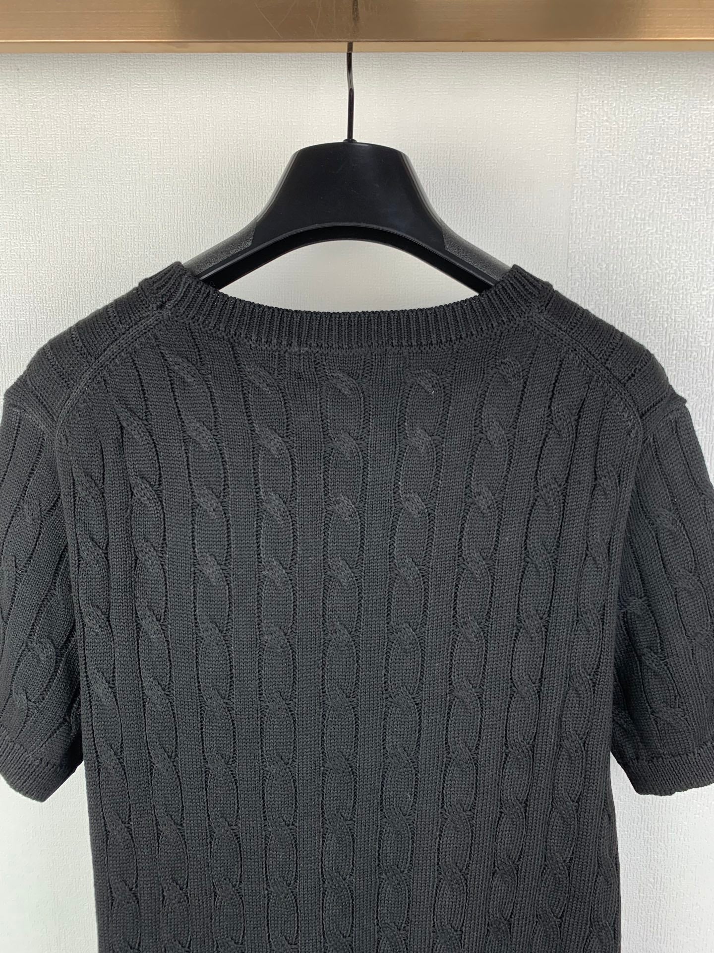 Cable-knit sweater back detail with raised cable stitch texture