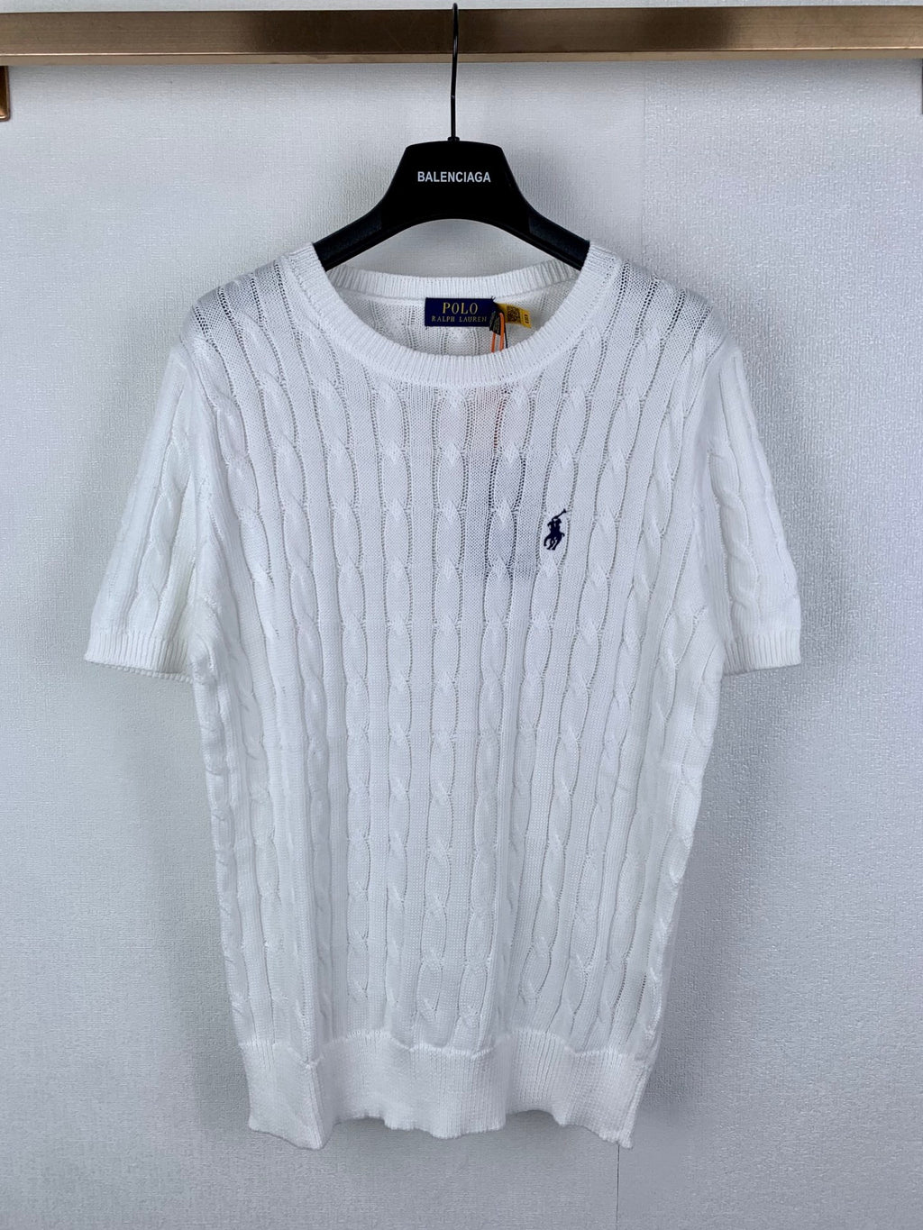 White cable-knit crewneck sweater with small navy polo logo on chest