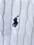 Small navy polo logo embroidered on white cable-knit sweater fabric