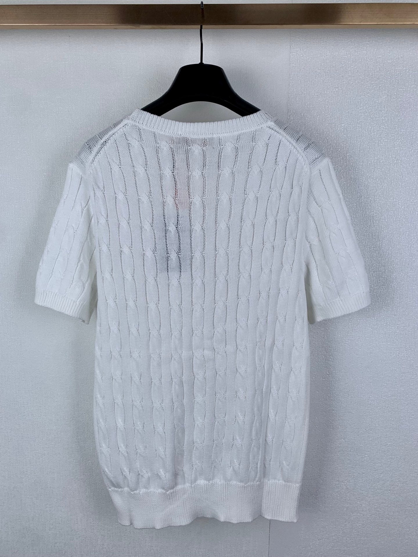 White cable-knit crewneck sweater, back view with ribbed hem and cuffs