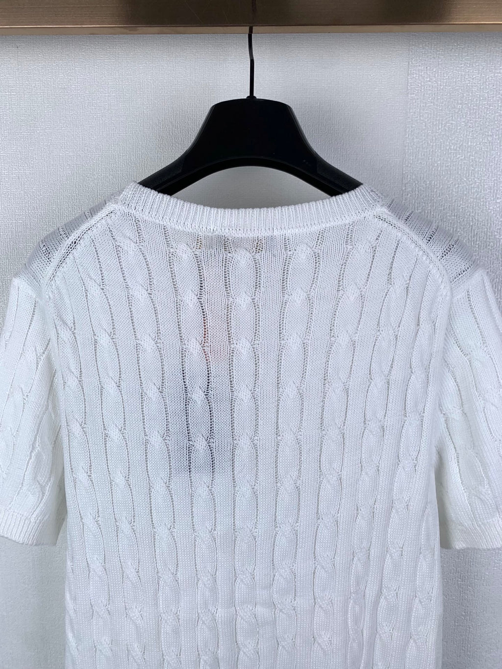 White cable-knit sweater neckline and upper back with ribbed trim