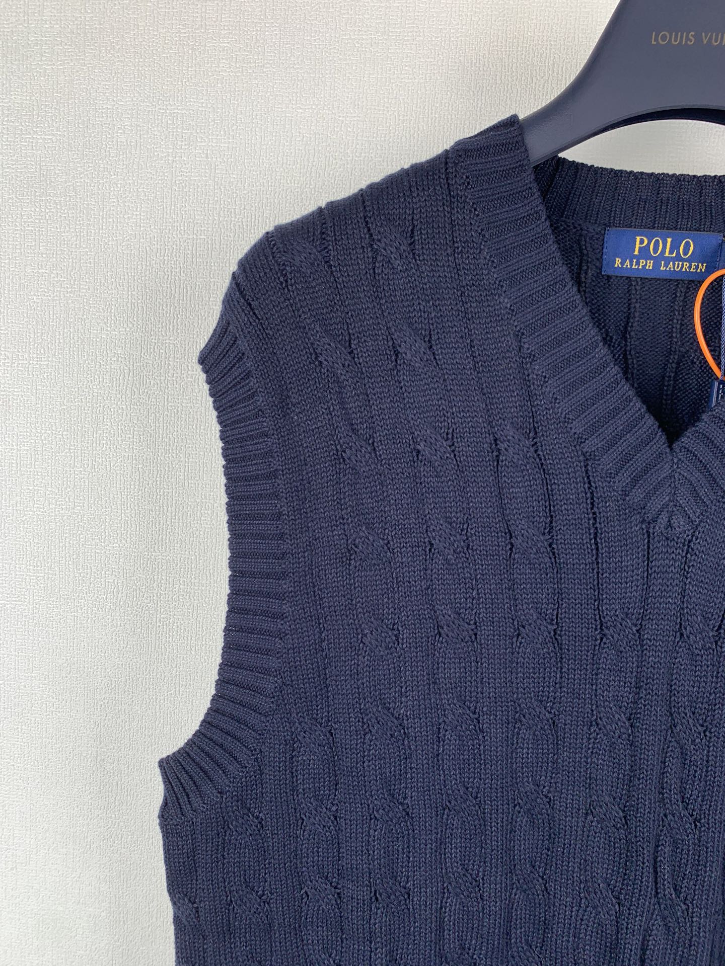 Navy cable-knit sweater vest shoulder with V-neck opening detail
