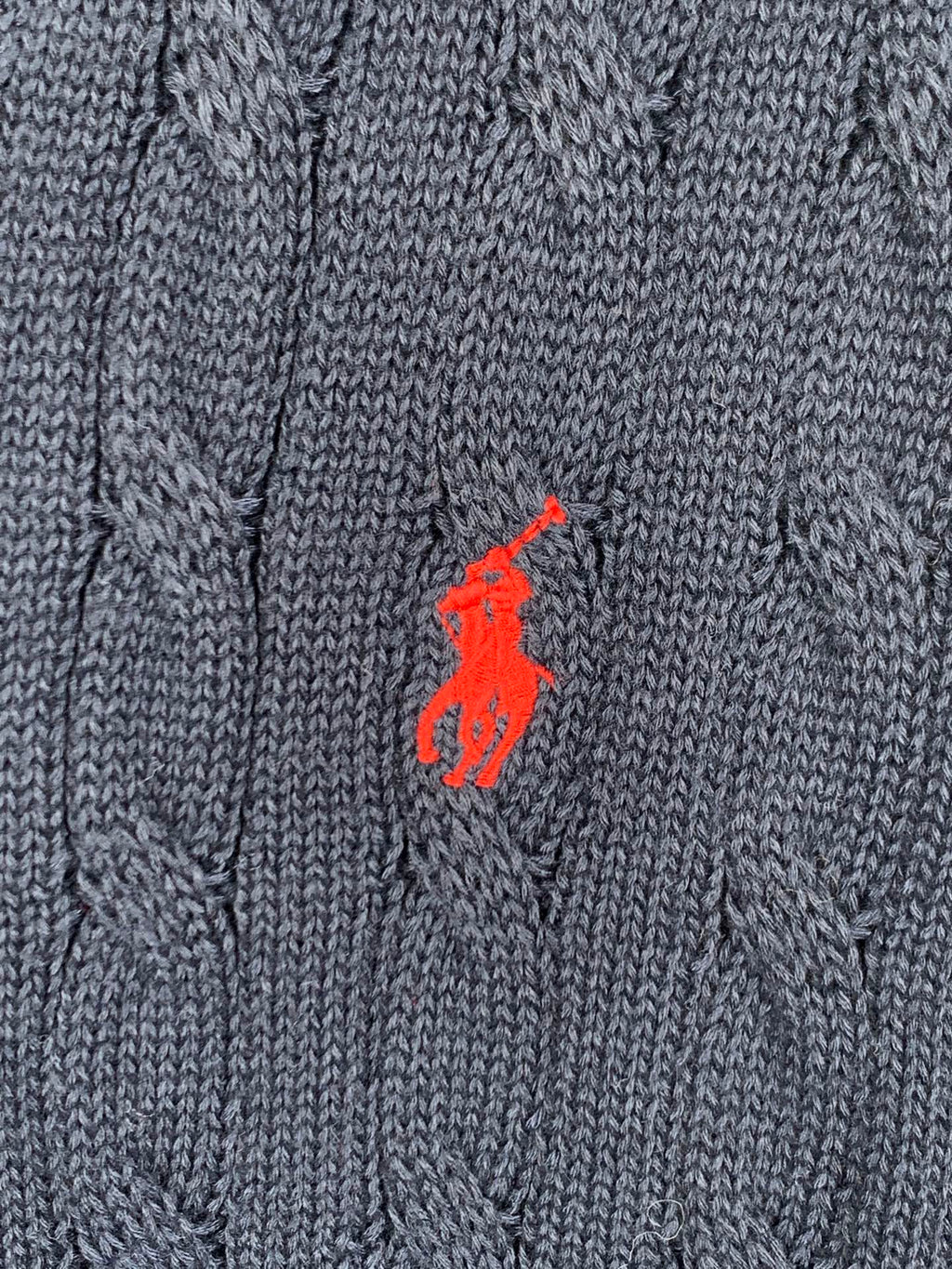 Red polo logo on navy cable-knit sweater fabric