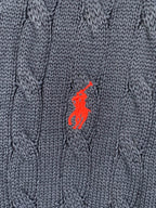 Red polo logo on navy cable-knit sweater fabric