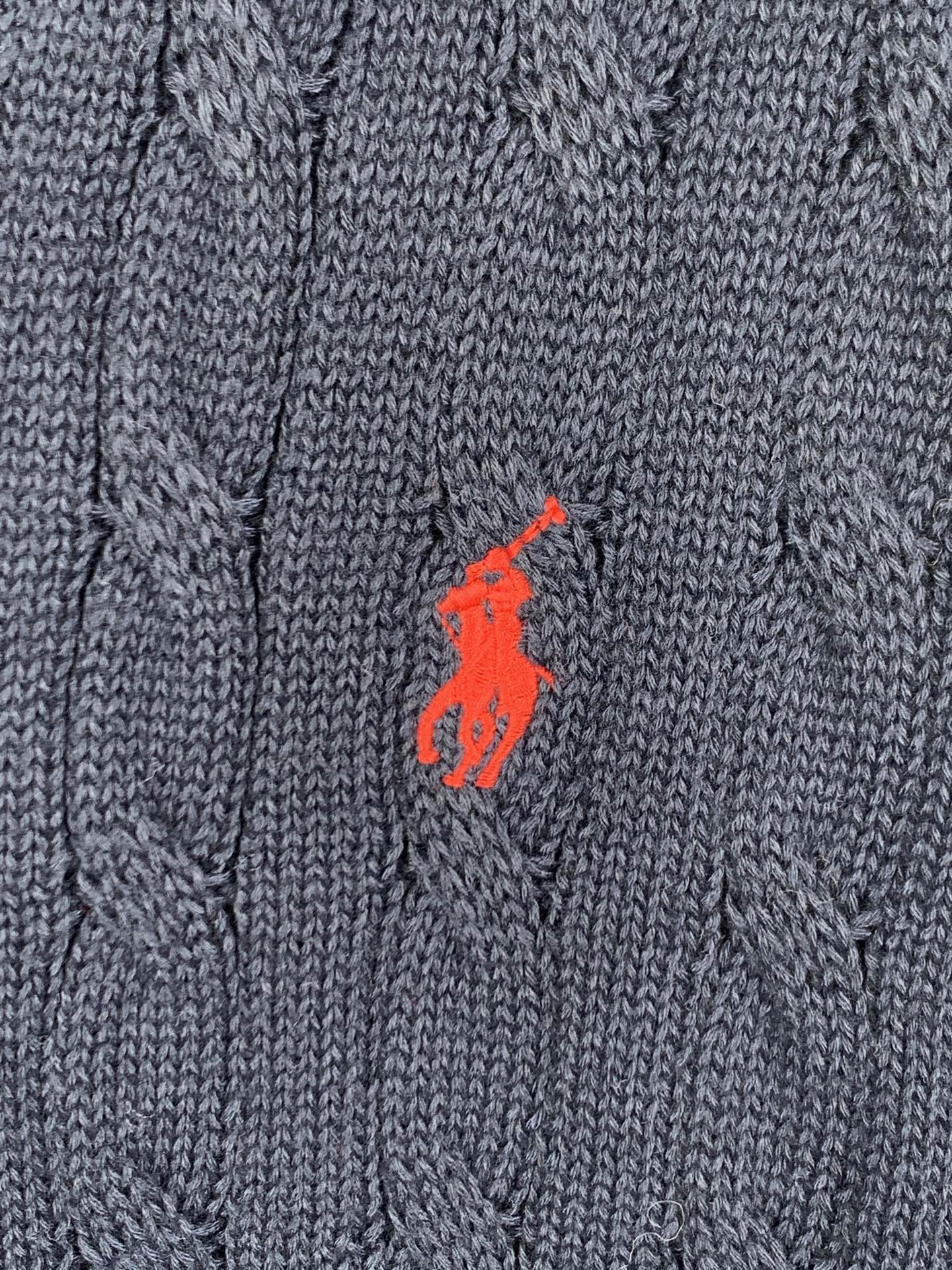 Red polo logo on navy cable-knit sweater fabric