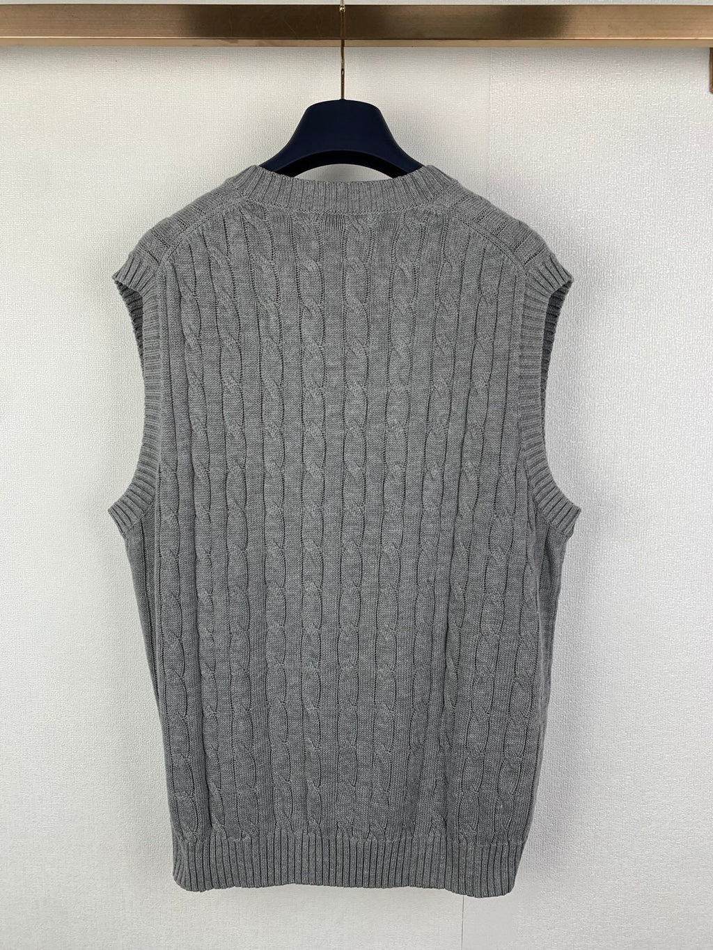Gray knit sleeveless sweater vest, cable texture, V-neck and ribbed hem
