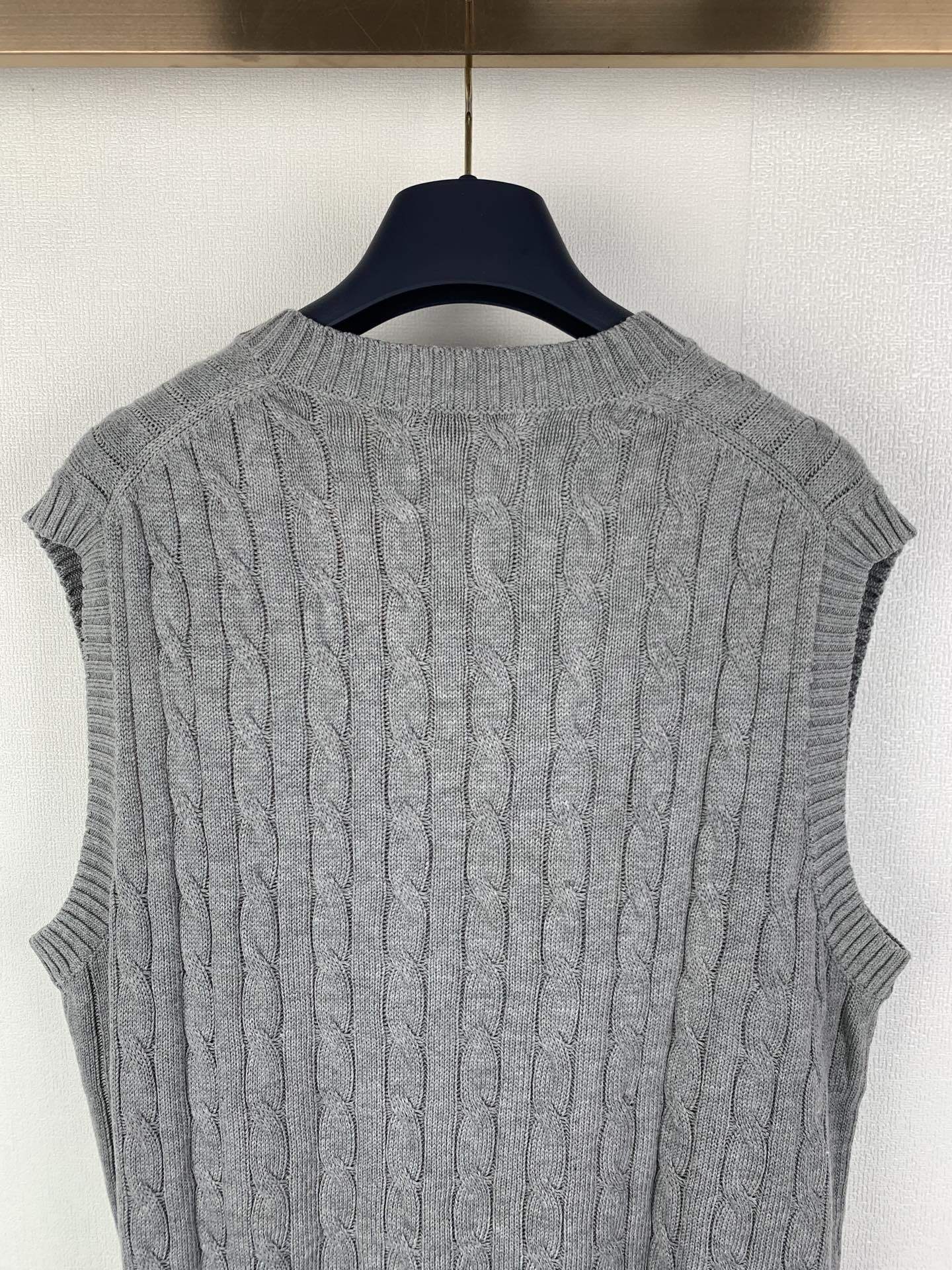 Gray cable-knit sleeveless sweater vest back view with ribbed neckline and hem