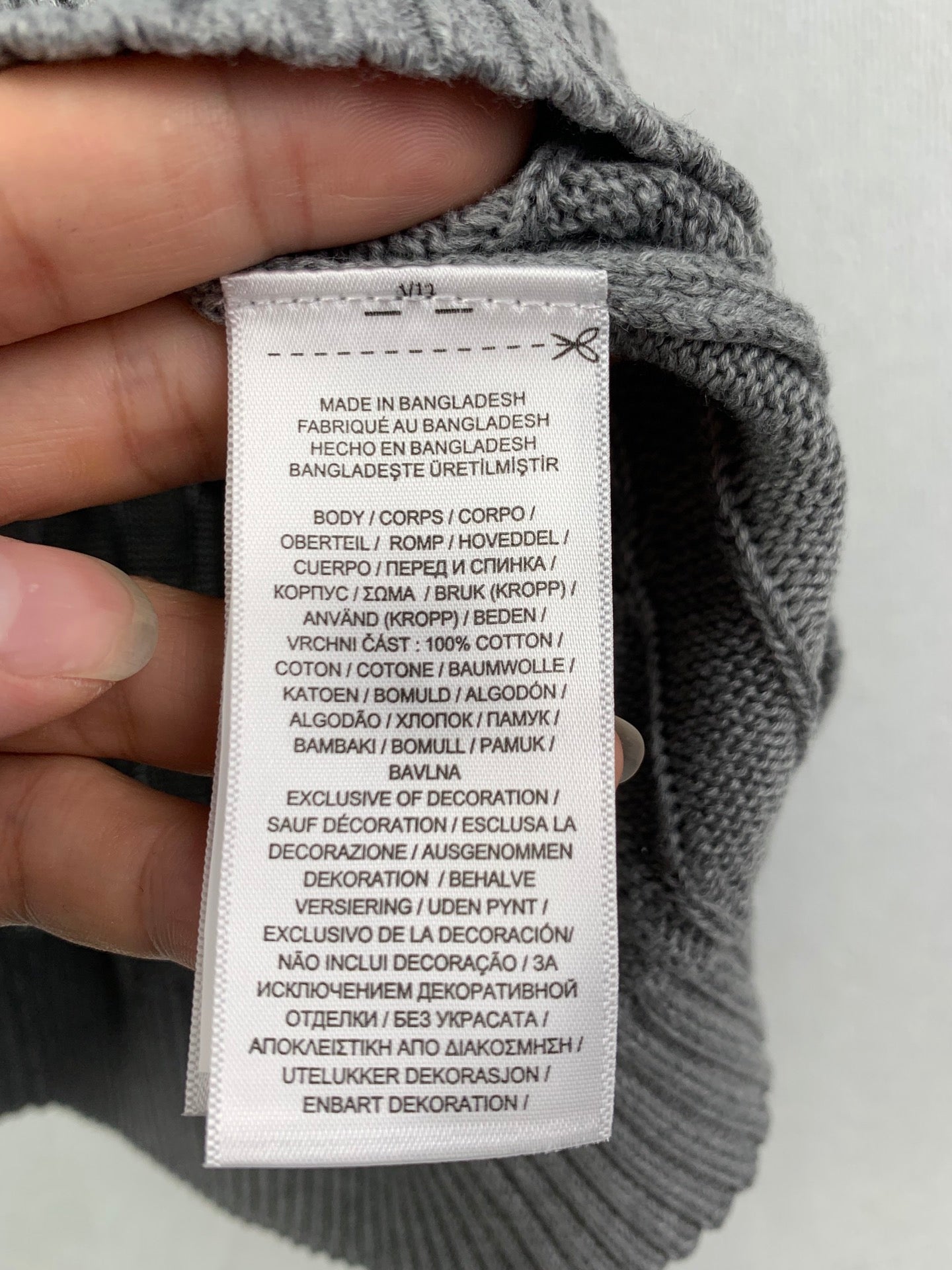 Gray knit sweater vest care label with fabric composition text