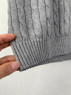 Gray ribbed knit hem with cable-knit texture on sleeveless sweater vest