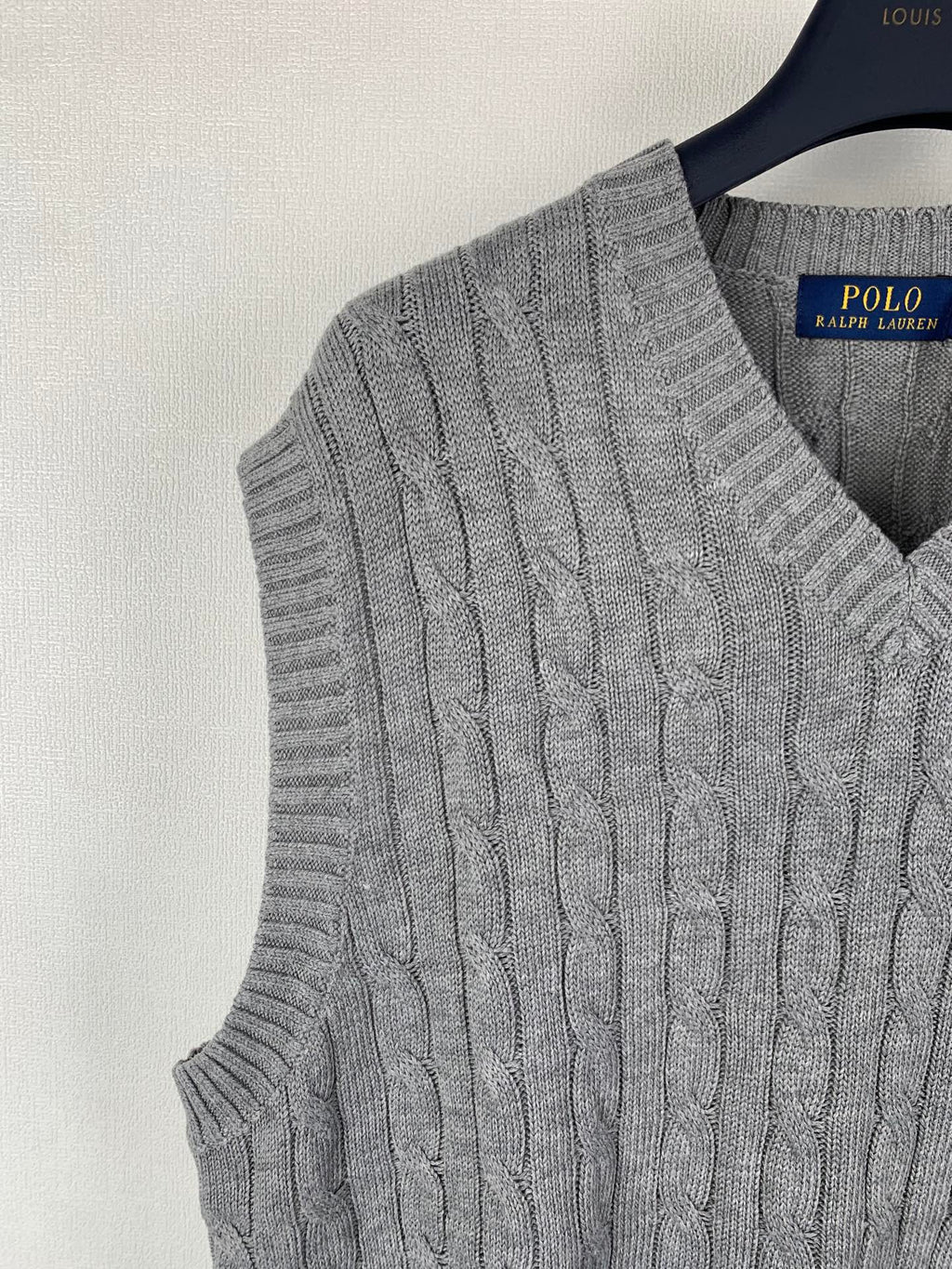 Gray cable-knit sleeveless sweater vest side view with V-neck ribbed trim