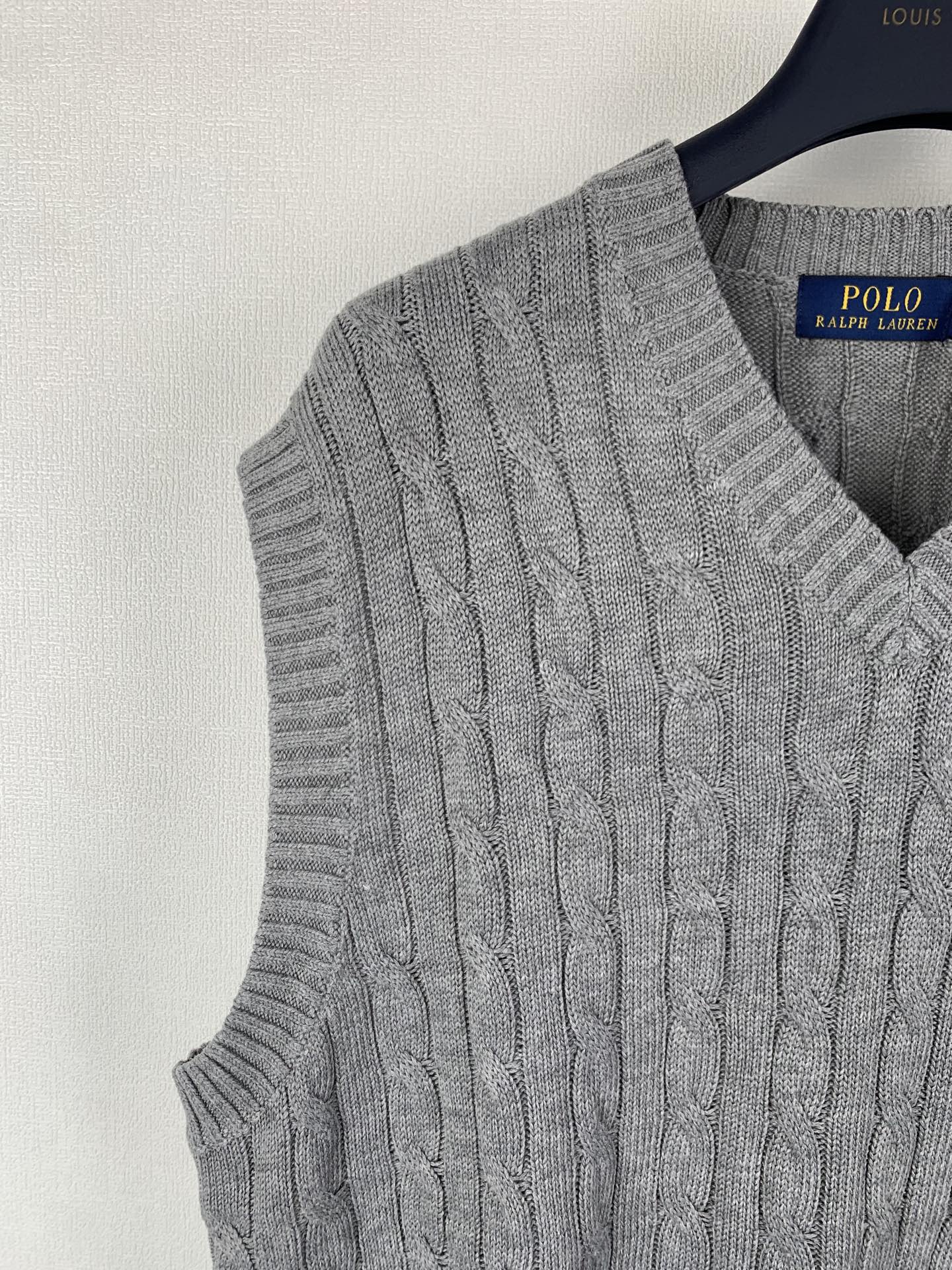 Gray cable-knit sleeveless sweater vest side view with V-neck ribbed trim