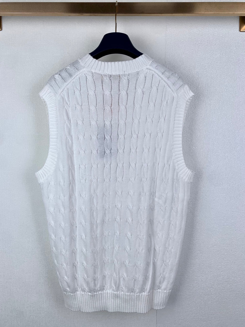 White cable-knit sweater vest with ribbed crew back collar