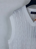 White cable-knit sweater vest detail with V-neck ribbed trim