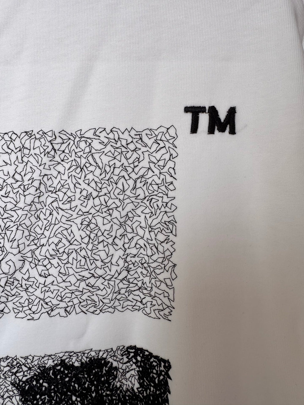 OffWhite™ T-shirt detail, off-white with textured arrow graphic and TM