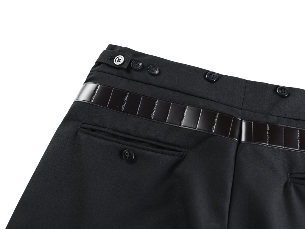 Black pants waistband close-up with button details and belt strap