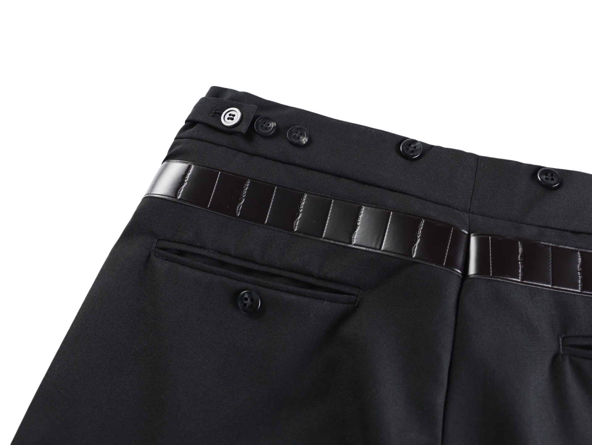 Black pants waistband close-up with button details and belt strap