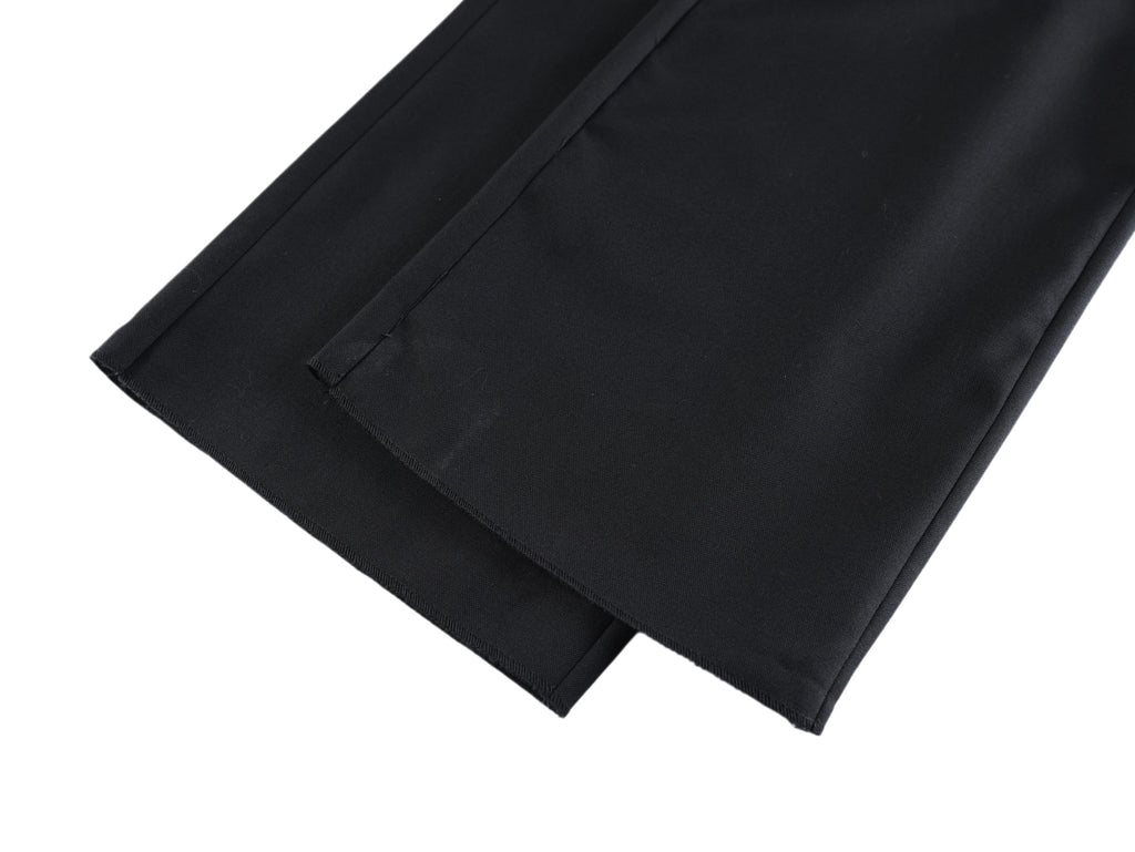Black pants leg with visible inner seam and folded hem