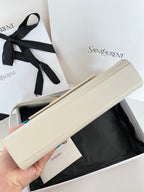 Cream leather handbag with gold-tone clasp, long side view held in hand