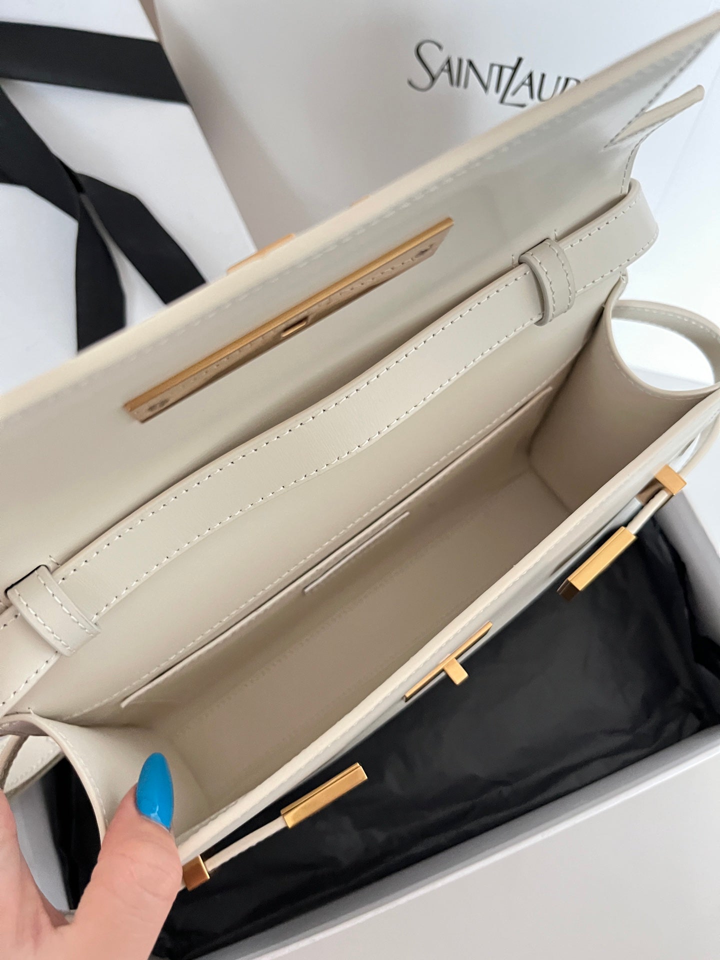 Cream leather handbag interior opening with gold-tone hardware on top edge