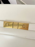 Cream leather handbag front clasp with gold-tone bar and snap details