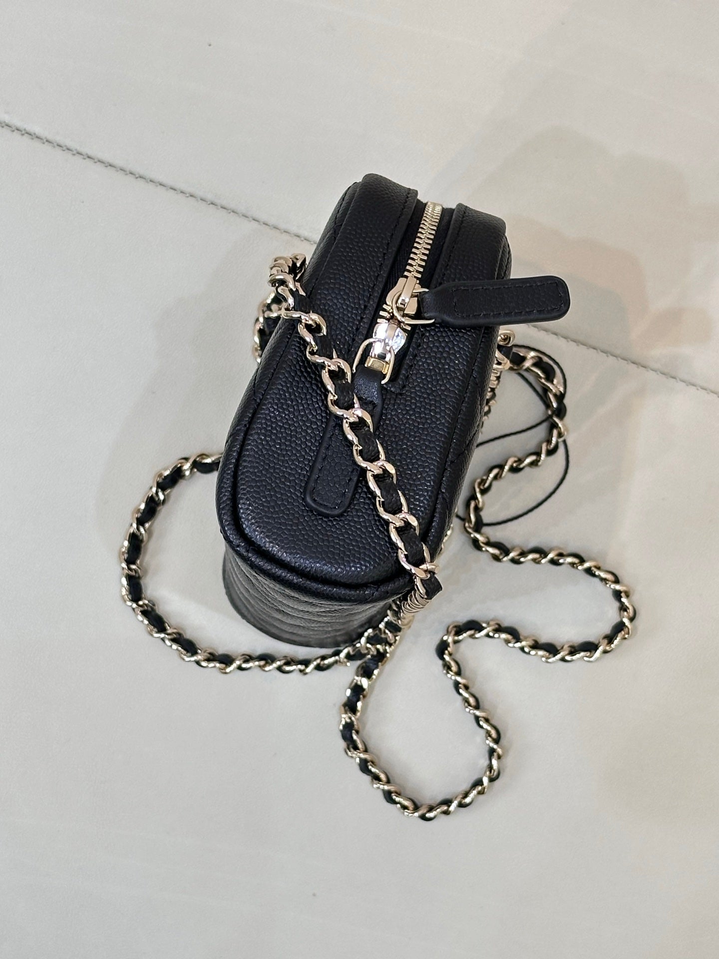 Chanel small quilted bag in dark blue with black strap detail and gold-tone chain