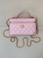 Pink quilted Chanel-style handbag with top handle, zipper top, and jeweled chain strap