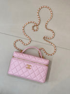 Pink quilted shoulder bag with top handle, gold logo charm, and jeweled chain strap