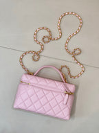 Pink quilted mini shoulder bag with gold zipper, logo charm, and jeweled chain strap